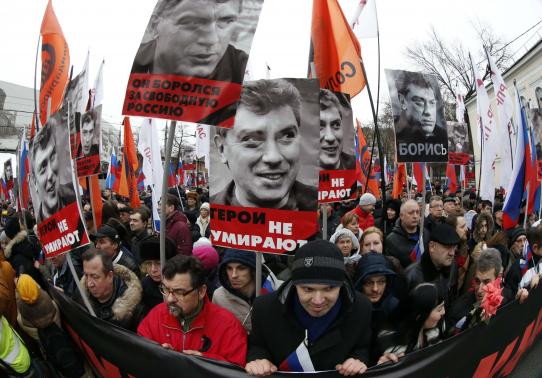 People hold flags and posters during march to commemorate Kremlin critic Nemtsov in central Moscow